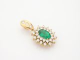 an emerald and diamond pendant on a white background