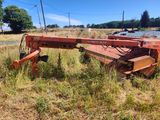 an orange tractor trailer sitting in the middle of a field