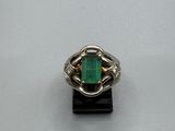 Gros plan sur une bague contenant une pierre verte