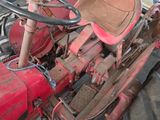 a red tractor that is parked next to a blue car