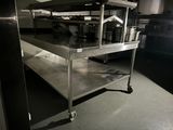 a metal shelf with pots and pans on it in a kitchen