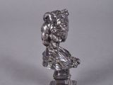 an antique silver figurine of a woman sitting on a pedestal