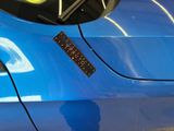 a close up of a blue car with a sticker on it