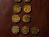 a lot of coins that are on a brown leather surface