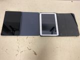 une tablette posée sur une table, à côté d'un téléphone portable