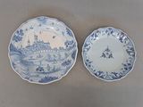 two plates with blue and white designs on them sitting on a table