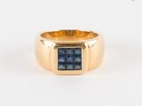 une image d'une bague en or avec une pierre bleue au centre