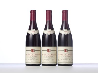 three bottles of red wine sit on a white surface