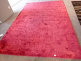 un tapis rouge posé au sol dans une pièce où se trouvent une chaise et une table