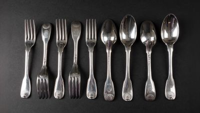 six spoons and six forks arranged in a row on a black surface