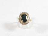 une image d'une bague en or avec une pierre verte entourée de diamants