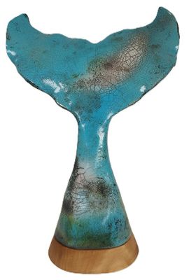 Sculpture représentant la queue d'une baleine bleue, posée sur un socle en bois, sur fond blanc