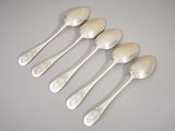 six silver spoons are lined up in a row on a table