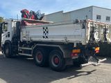 a white dump truck parked in front of a building