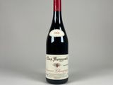 une bouteille de vin rouge posée sur une table blanche