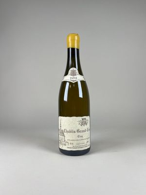 une bouteille de vin blanc posée sur une table blanche