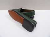 a pair of green loafers on a white surface