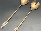 pair of silverware spoons with handles on a black surface