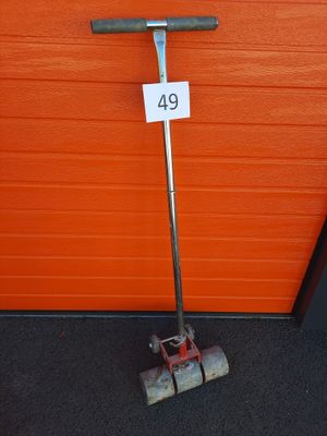a broom that is sitting on the ground next to an orange wall