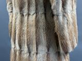 the back view of a woman ' s fur coat with a hood