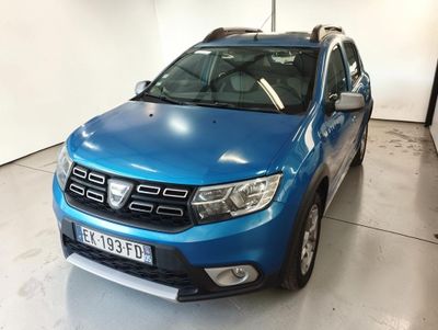une Dacia bleue garée dans un garage aux murs blancs
