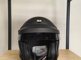 un casque ouvert posé sur une étagère en bois, à côté d'une paire de ciseaux
