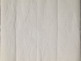 an old piece of white paper on a wooden table