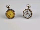 deux petites montres de poche posées côte à côte sur une surface blanche