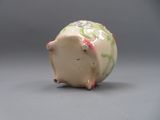 une petite figurine de cochon posée sur une table