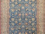 a blue rug with a red border and a floral design