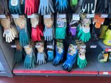 several pairs of gardening gloves are on display in a store