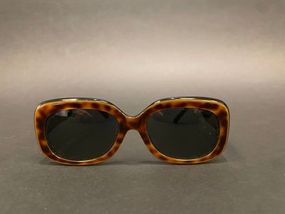 a pair of tortoise sunglasses on a gray surface