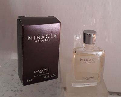 l'image d'un flacon de parfum à côté d'une boîte