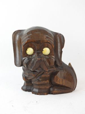 a wooden statue of a dog with yellow eyes