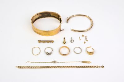 de nombreuses bagues et bracelets en or posés sur un fond blanc