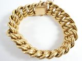 a close up of a gold bracelet on a white background