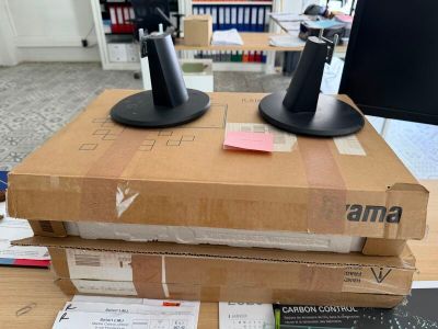 deux écrans d'ordinateur posés sur une boîte en carton