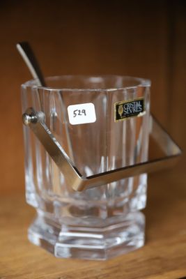un verre contenant une cuillère, posé sur une étagère