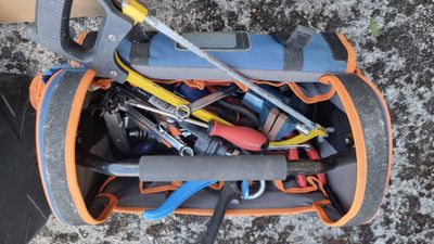 a bag full of tools sitting on the ground