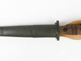 a close up of a knife with a wooden handle on a white surface
