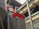 a large metal tank that has a red bucket on top of it