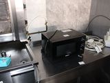 a microwave sitting on top of a counter next to a sink