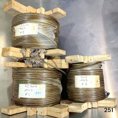 several rolls of wire are stacked on pallets on a metal surface