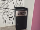 a black and white drawing on the wall next to a trash can