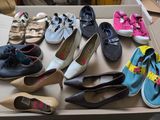plusieurs paires de chaussures dans une boîte posée sur le sol