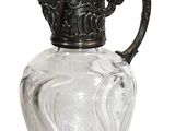 a glass pitcher with a metal lid on a white background