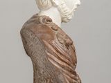 statue of a bust of a man with long hair on a wooden table