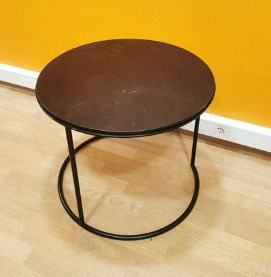 a black table with a brown top on a wooden floor