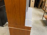 a tall wooden cabinet in the middle of a room