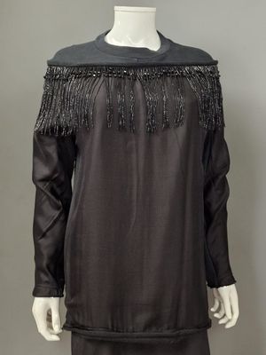 une robe noire avec des franges sur les épaules et les épaules
